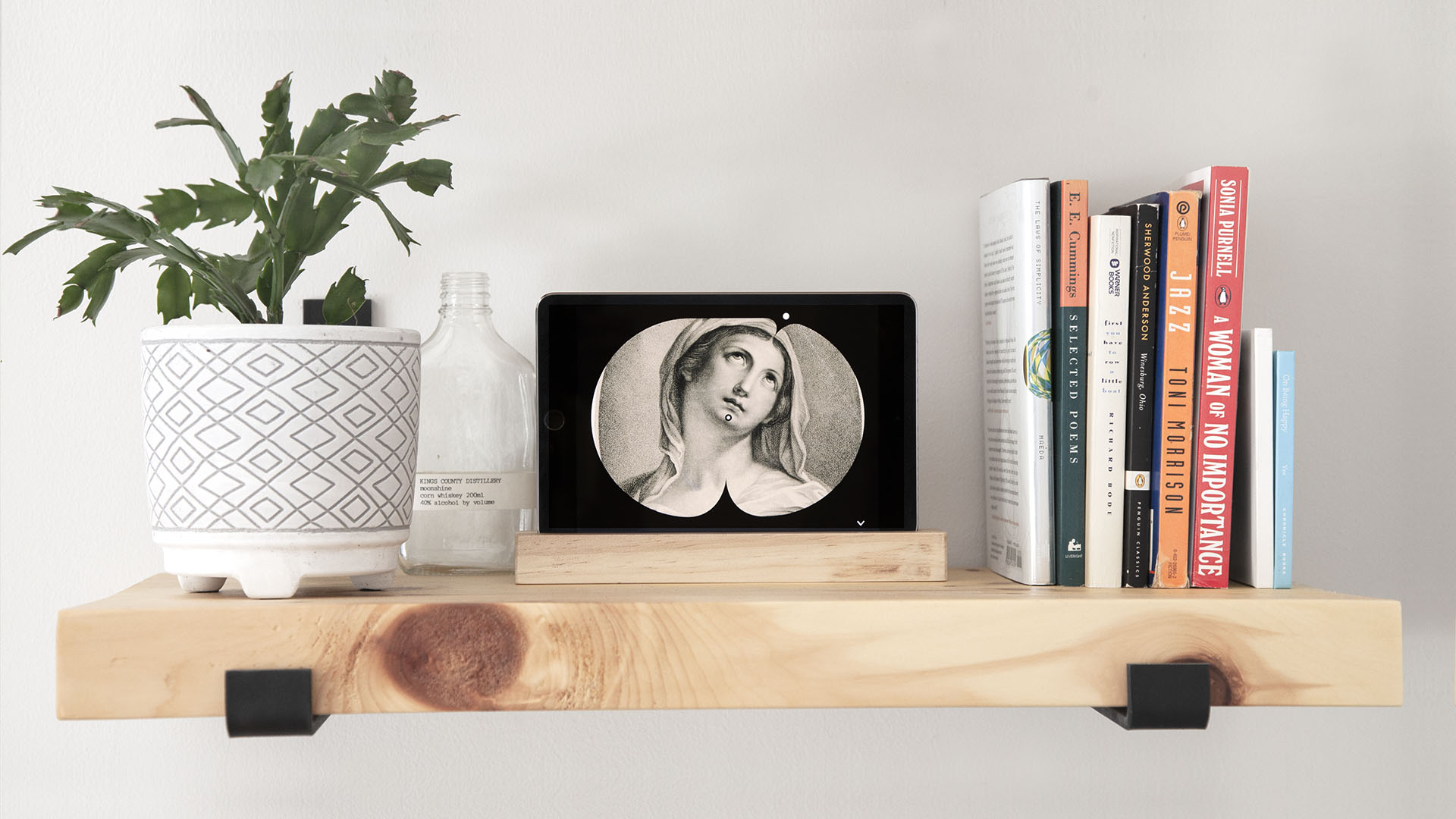 art clock displayed on a tablet resting on a shelf as part of decor