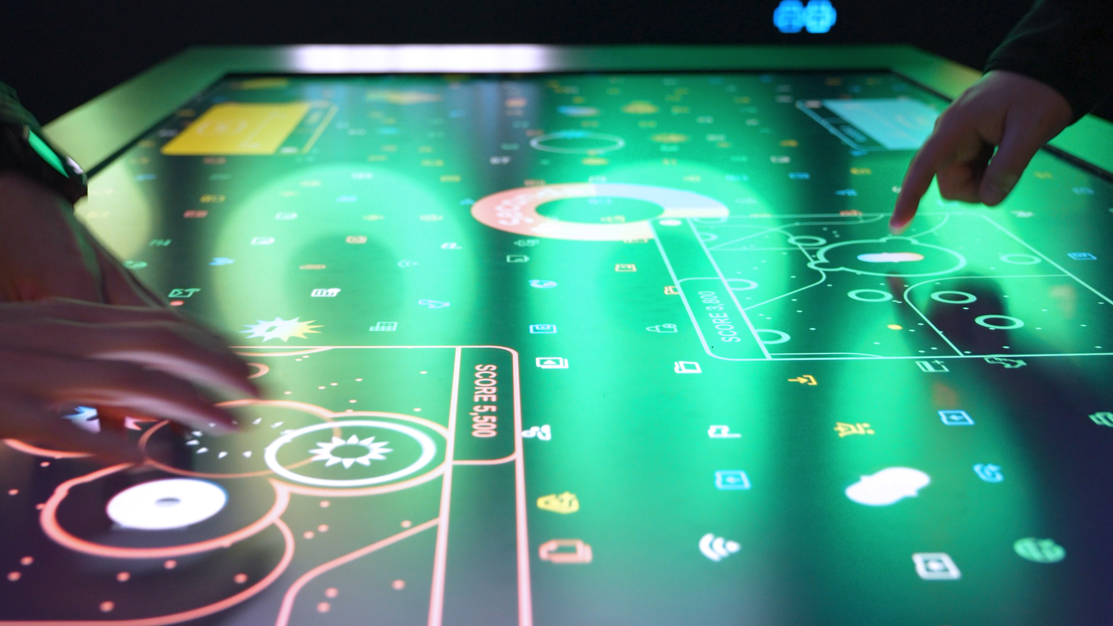 Close up of the touchscreen table display showing exploding threats during the Data Defense gameplay.