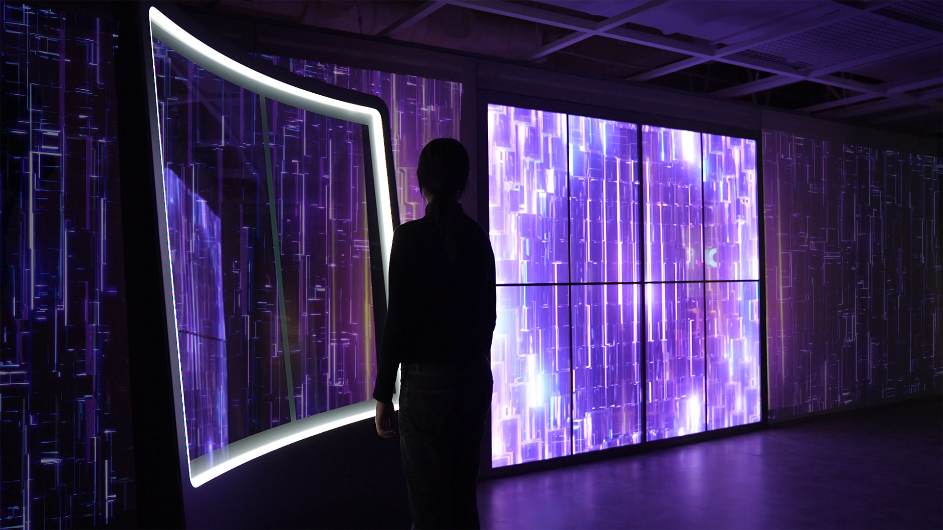 a dark room with a large interactive transparent led screen with woman interacting. purple crystal refractive graphics on screen