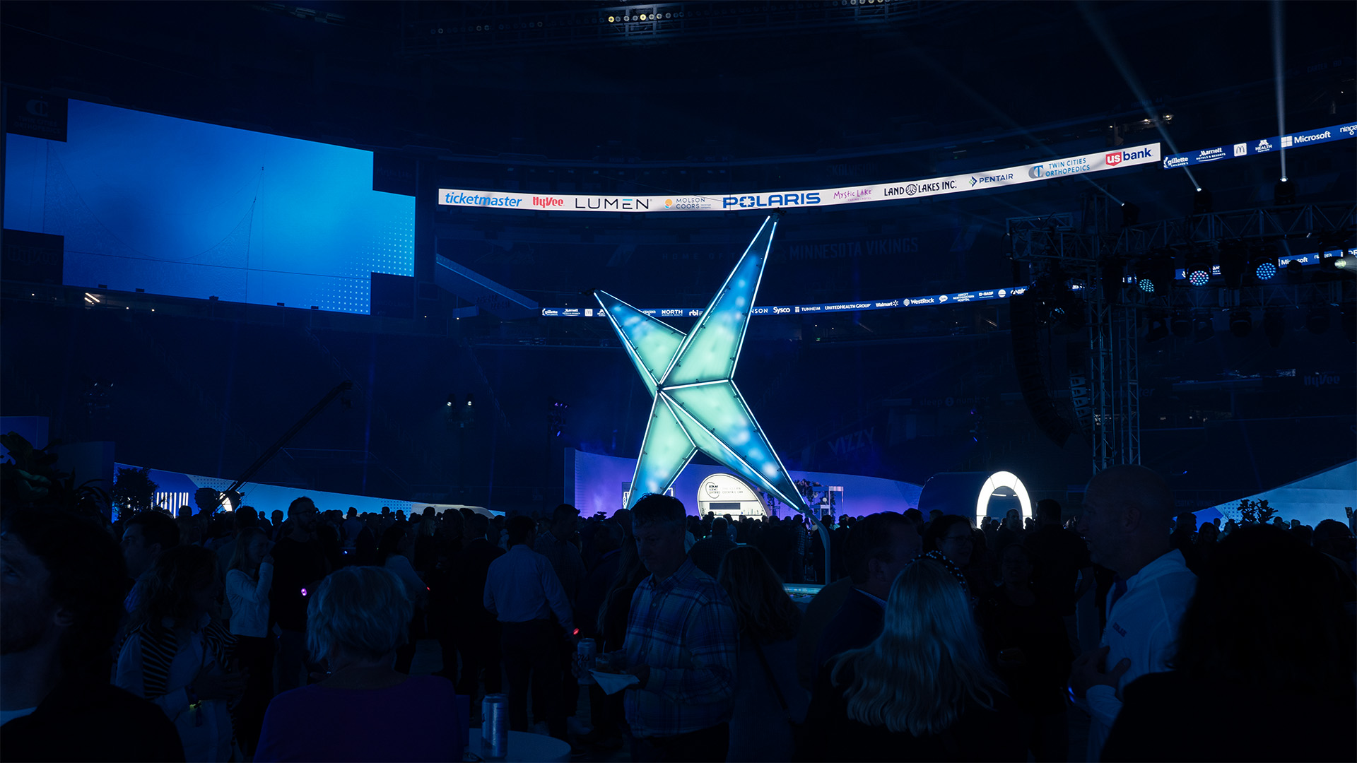 The spark is playing an animation of blue particles responding to the concert. A large crowd of people enjoys themselves around the sculpture